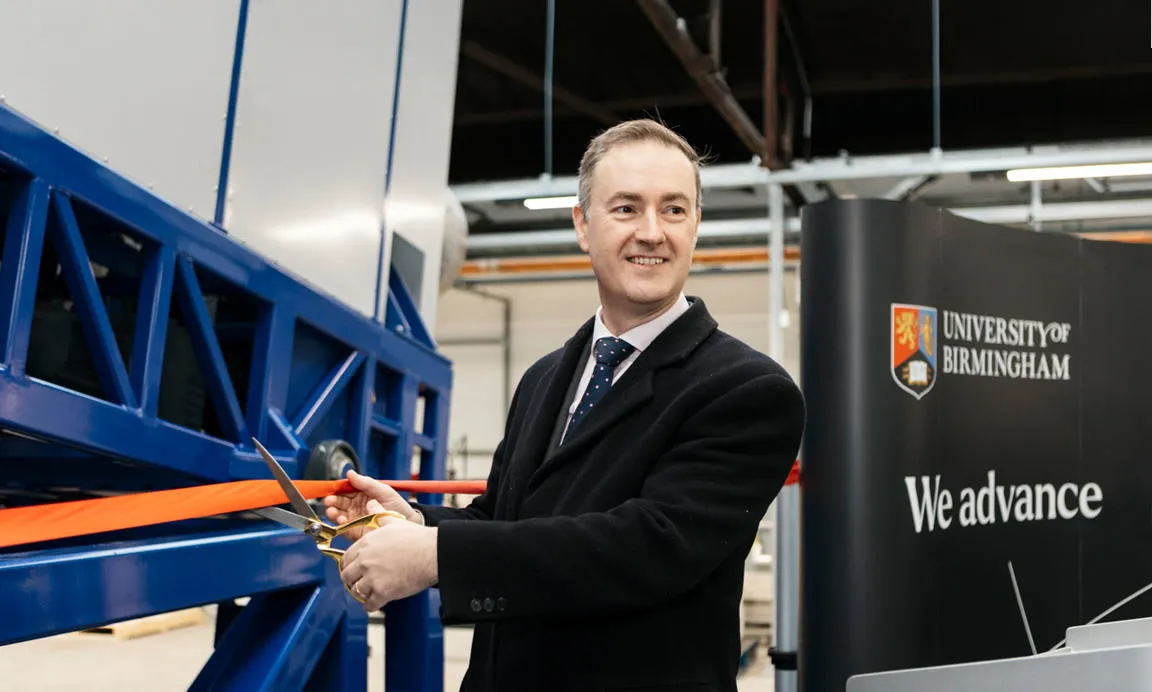 Chris McDonald MP cutting a ribbon at the official opening of the rare earth recycling plant